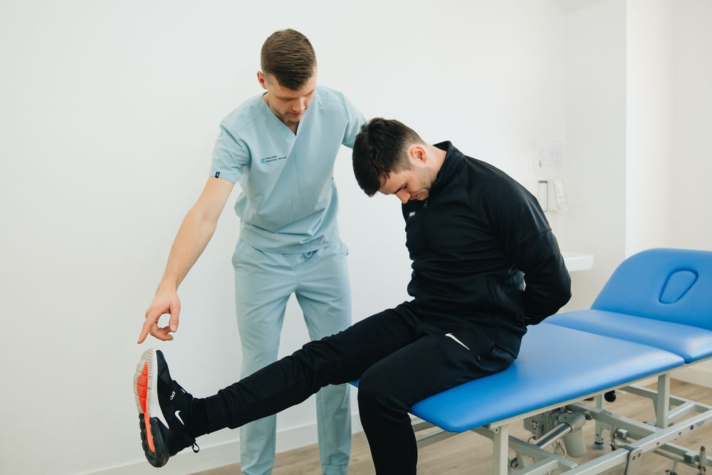 Physiotherapist guiding a seated patient through a leg exercise to support mobility and recovery