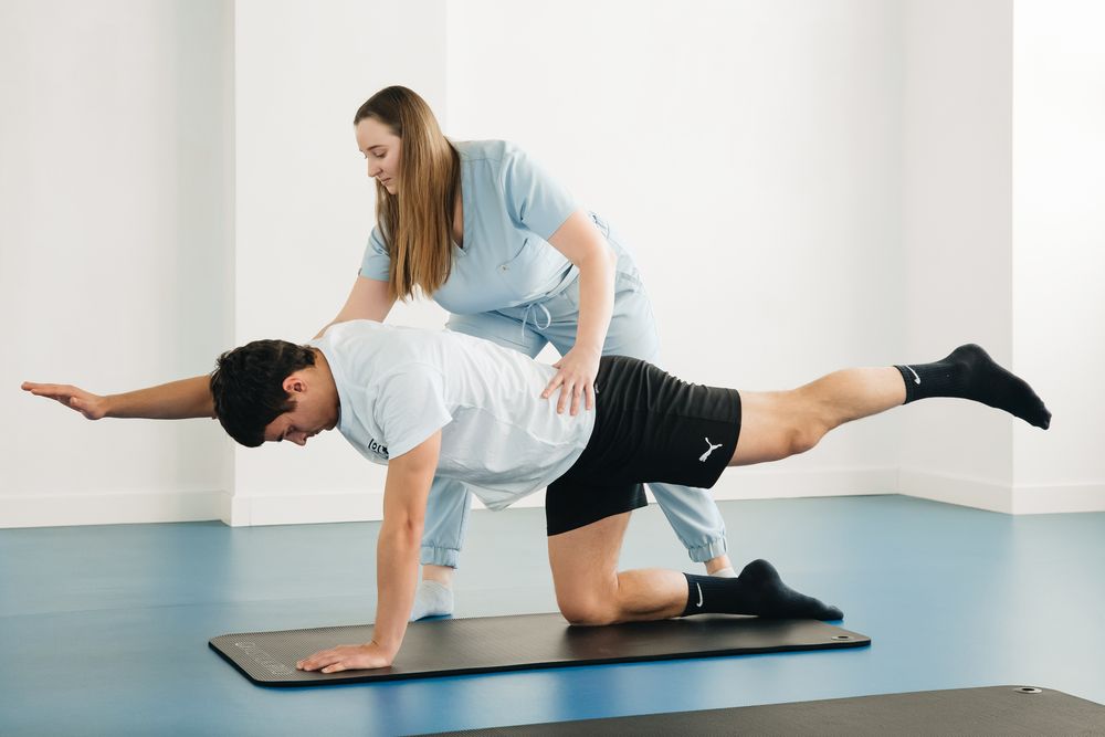 Physiotherapist supporting a patient during a balance exercise