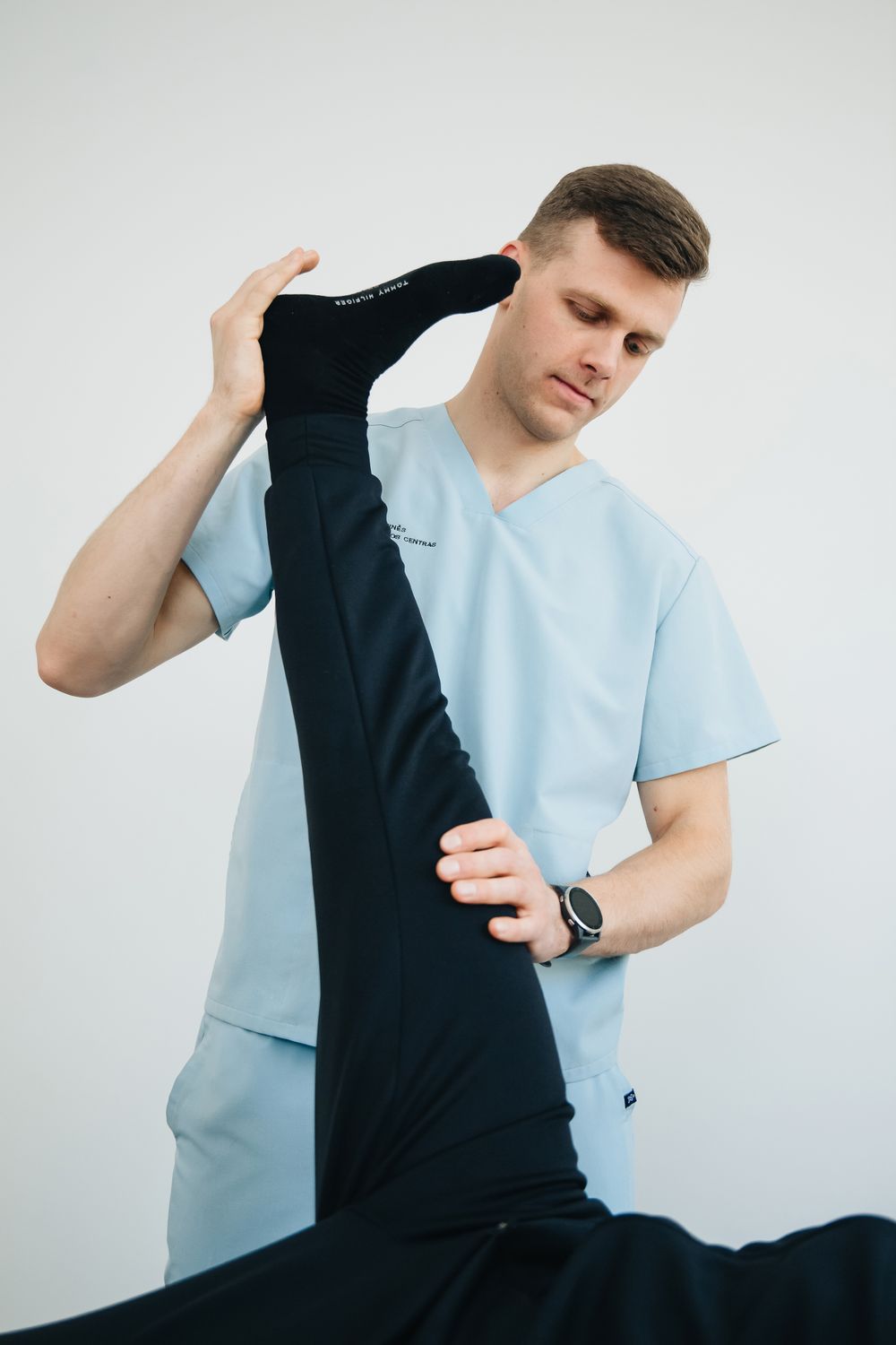 Physiotherapist supporting a patient during a leg stretch