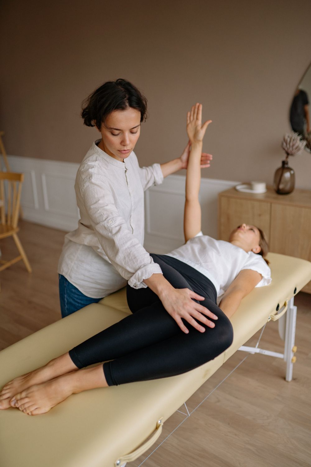 Physiotherapist guiding a patient through rehabilitation on a treatment table